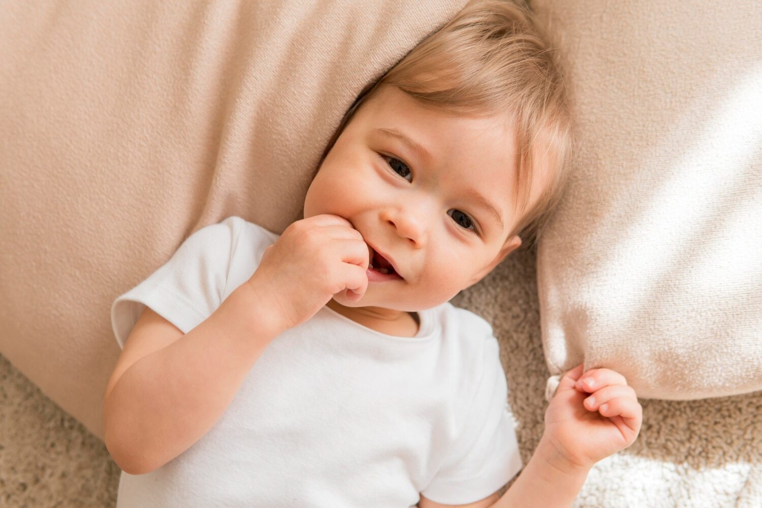 Toddler with hand in mouth demonstrating why using teeth as tools is harmful.