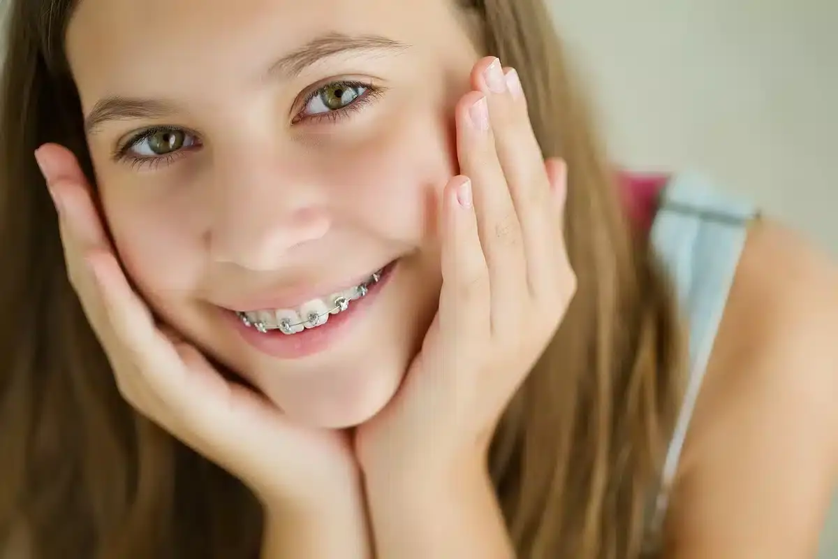 Happy teenager with metal braces smiling at dental practice in Spring, TX.