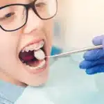 Young patient receiving dental examination with orthodontic braces during early orthodontic care evaluation.