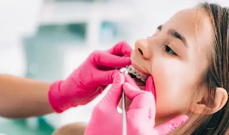 Young patient displaying metal braces during orthodontic examination and care.