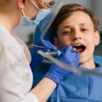 Young boy receiving pediatric dental examination from dentist in Spring, TX.