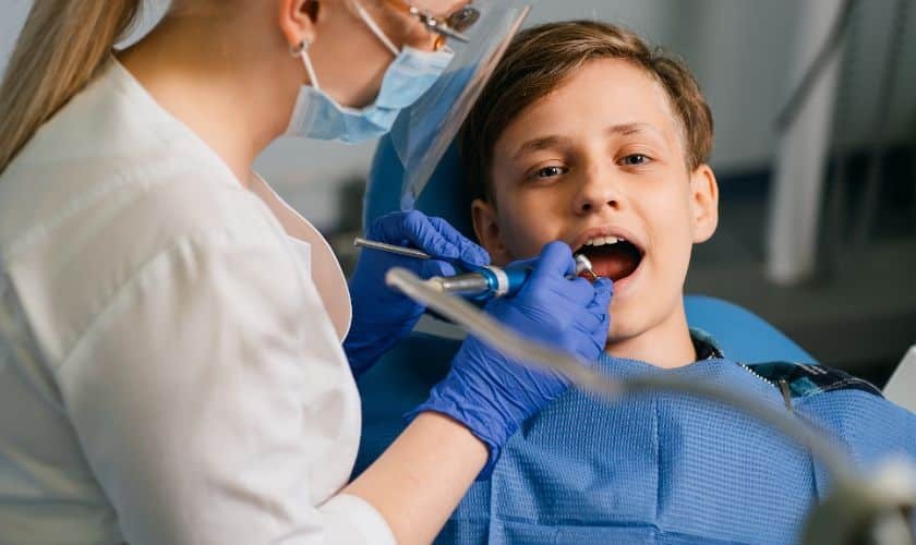 Young boy receiving pediatric dental examination from dentist in Spring, TX.