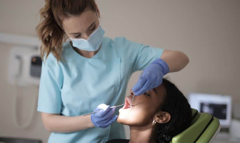 Pediatric dentist examining a child patient's teeth during a dental visit in Spring, TX.