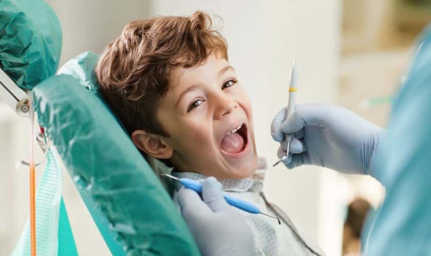 Young boy smiling with mouth open during dental examination at Spring pediatric dental office.
