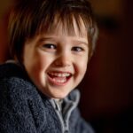 Happy child smiling with healthy teeth in dental practice setting.