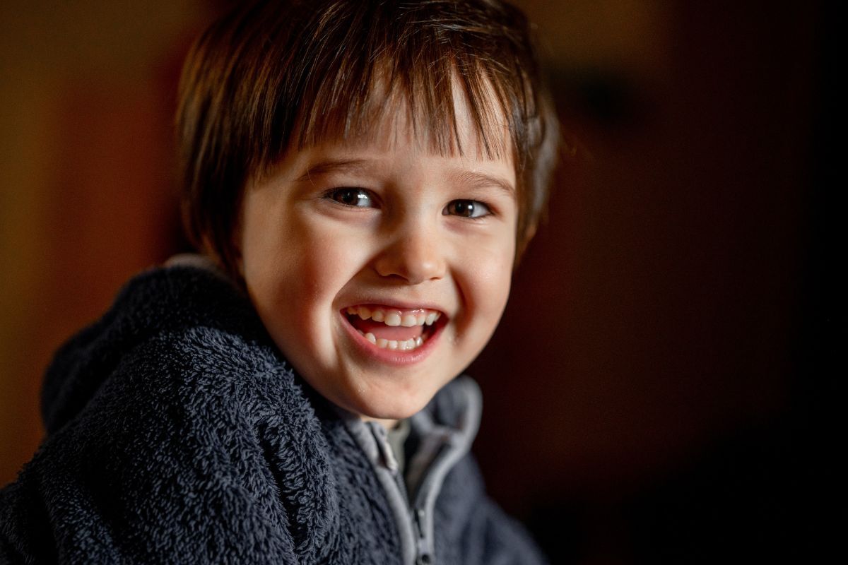 Happy child smiling with healthy teeth in dental practice setting.