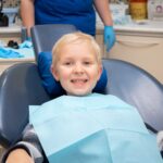 Happy young patient in dental chair during examination at Spring, TX pediatric dental practice.