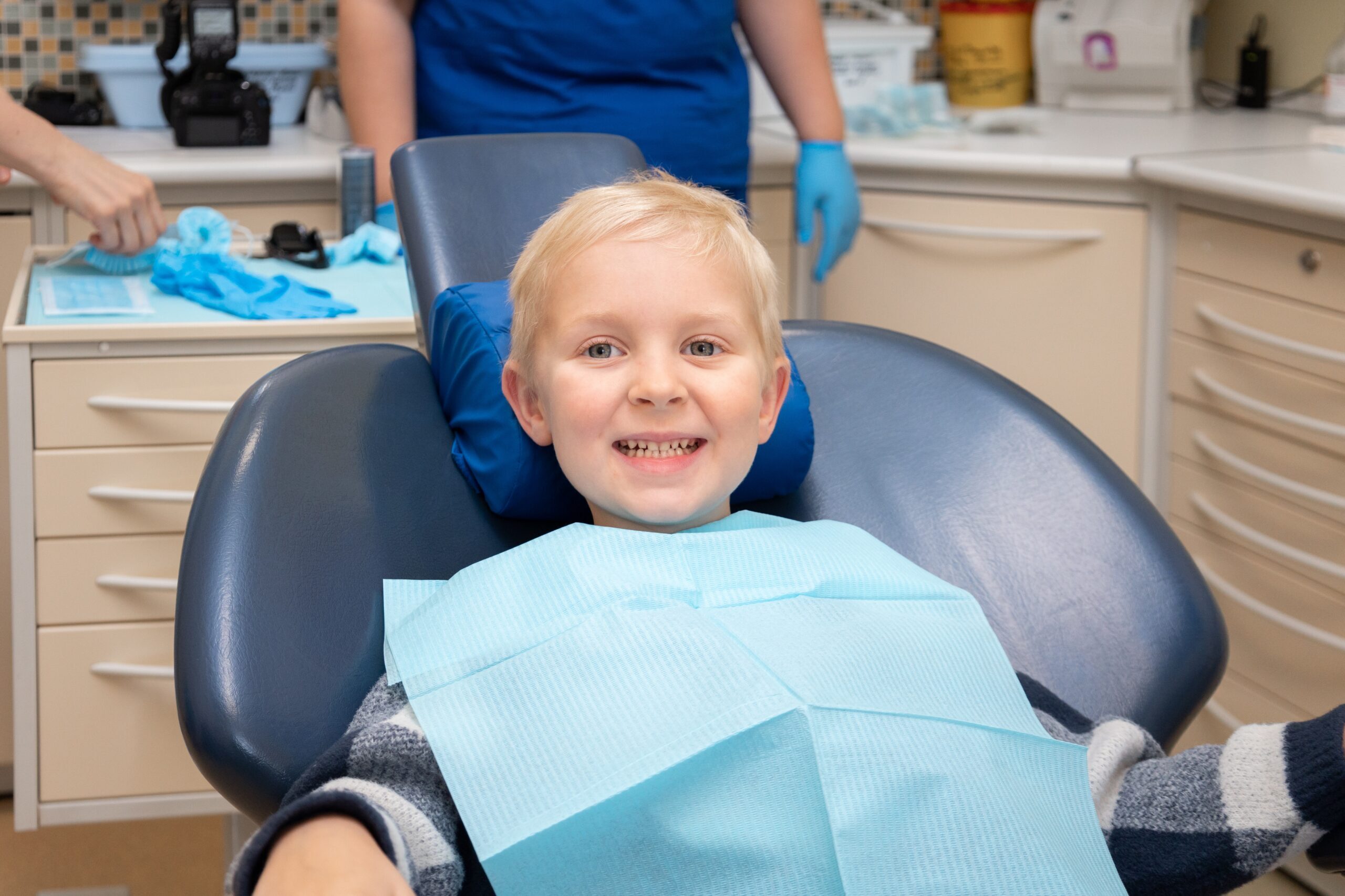 Happy young patient in dental chair during examination at Spring, TX pediatric dental practice.