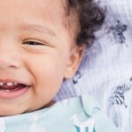Happy toddler smiling, showing primary teeth during early childhood development.