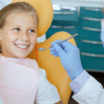 Young patient smiling during dental examination in Spring, TX dental office.