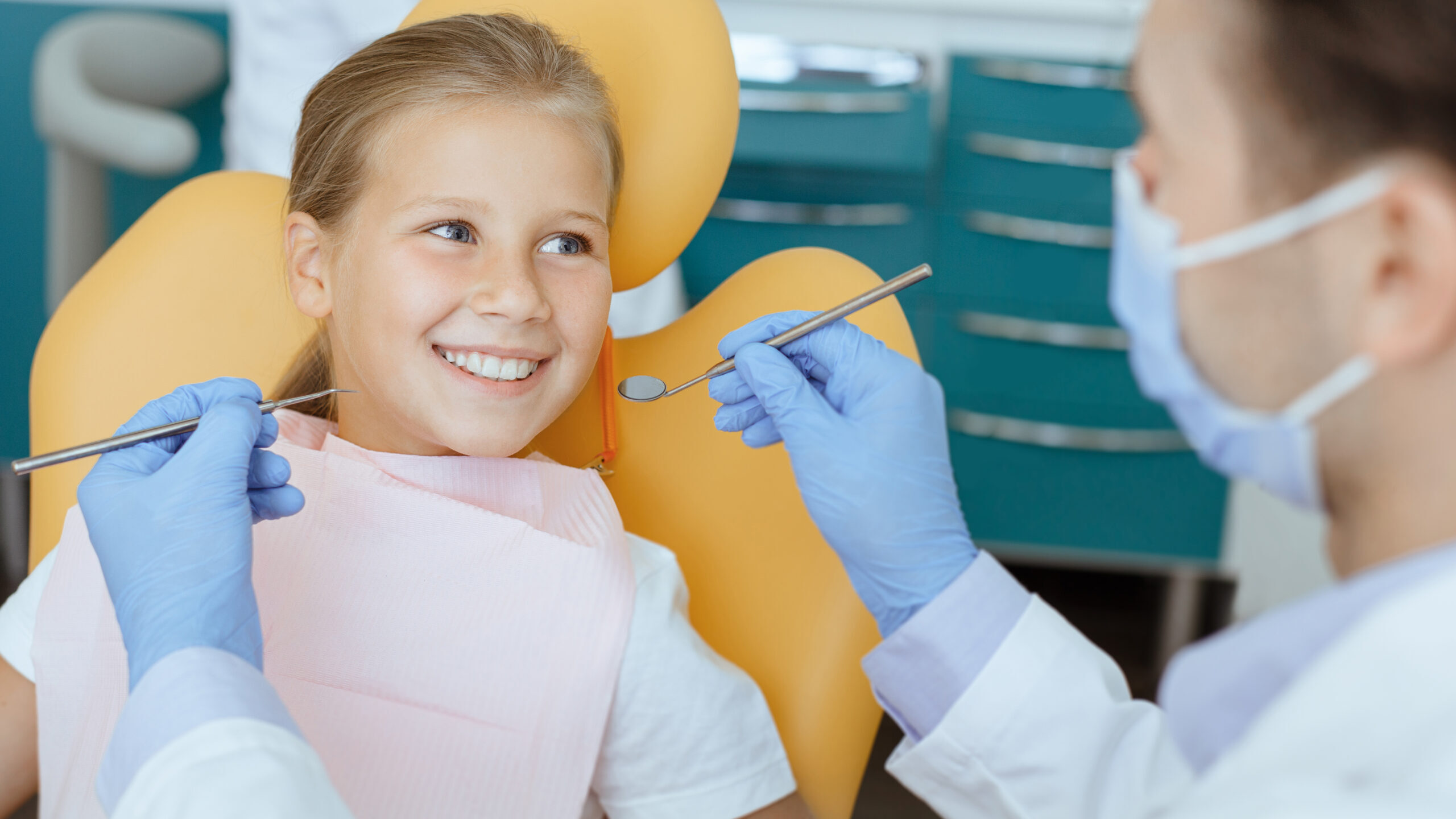 Young patient smiling during dental examination in Spring, TX dental office.