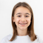 Young girl with braces smiling at dental office in Spring, TX.