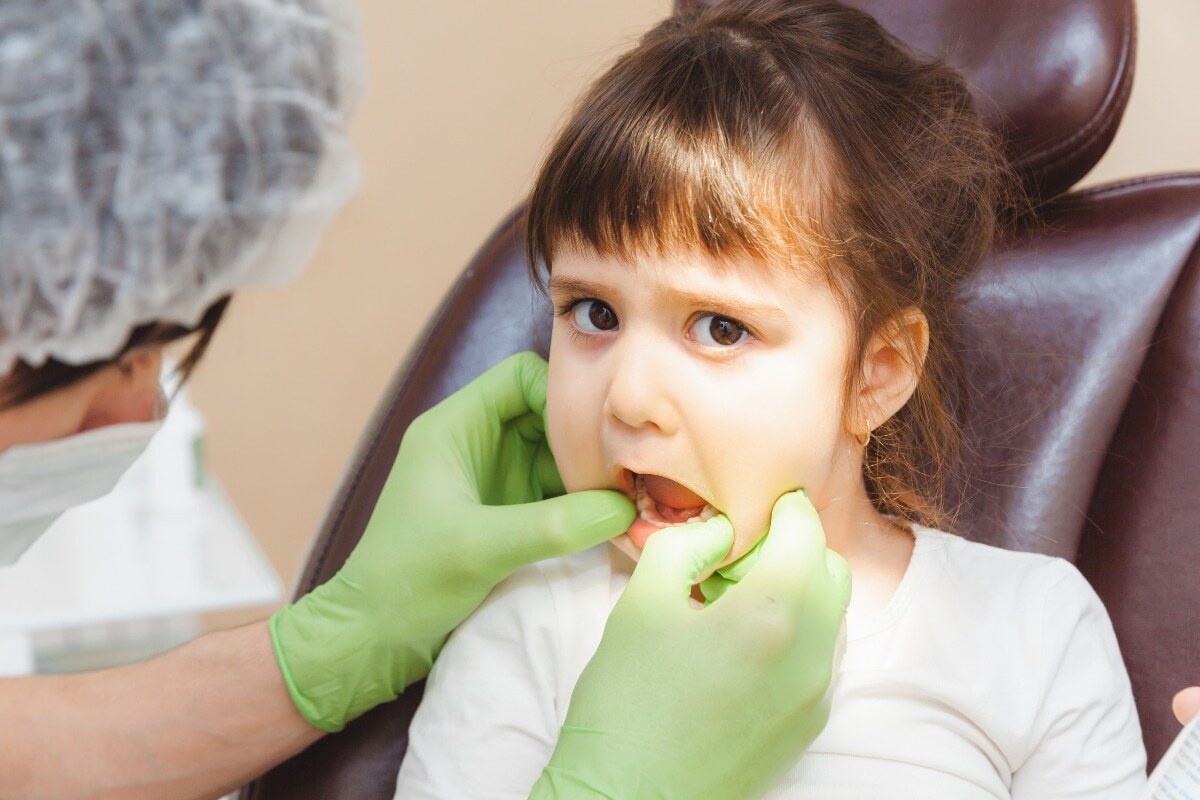 Young patient receiving dental examination in chair at Spring pediatric practice.