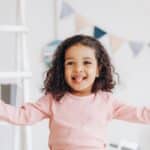 Child smiling with a missing baby tooth during play