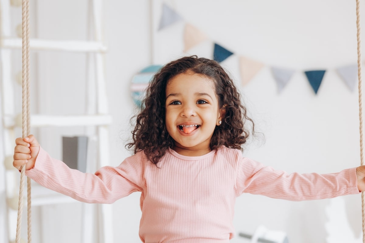 Child smiling with a missing baby tooth during play
